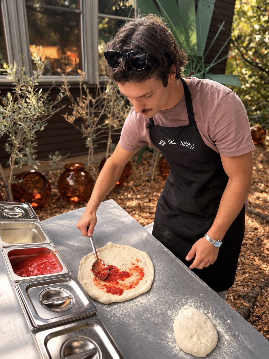 Sinkó Zsombor szósszal készíti elő a pizzát